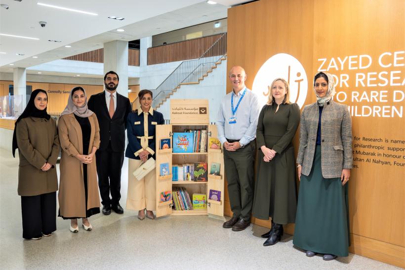 عدد من الأشخاص واقفون في شكل ضلعي مثلث ومبتسمون للكاميرا وورائهم لافتة مركز زائد للأبحاث على الحائط.